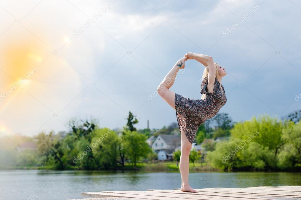 Miracle dancer: image of wonderfully dancing girl blond young sensual pretty woman in light dress at water lake on lighting rays sunshine blue sky outdoors background and looking at copy space