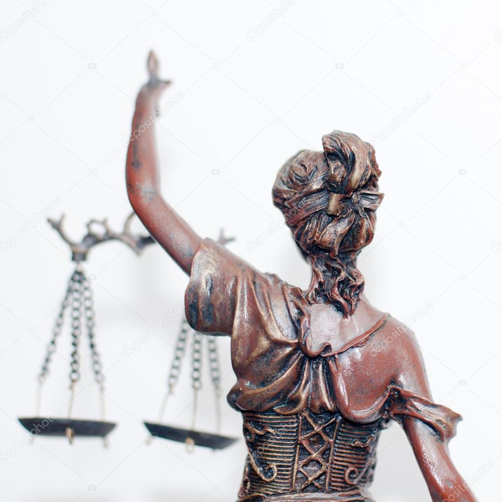 close up picture of lady justice or themis goddess standing back holding scales blindfold on white background