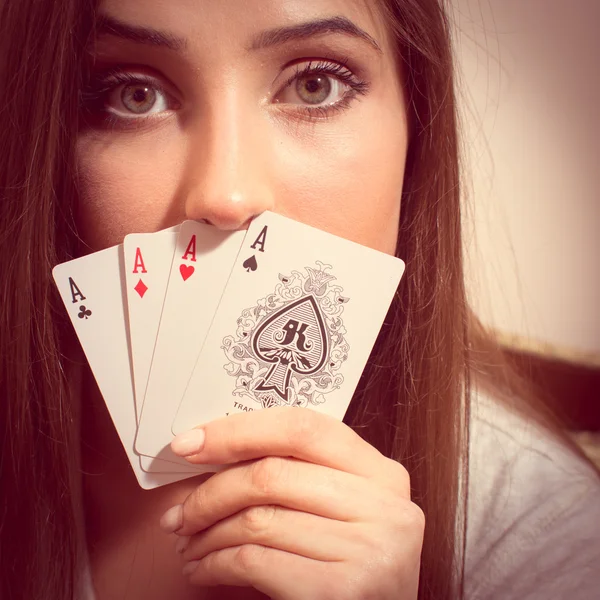 Дівчина грає в карти, що тримають чотири аси — стокове фото