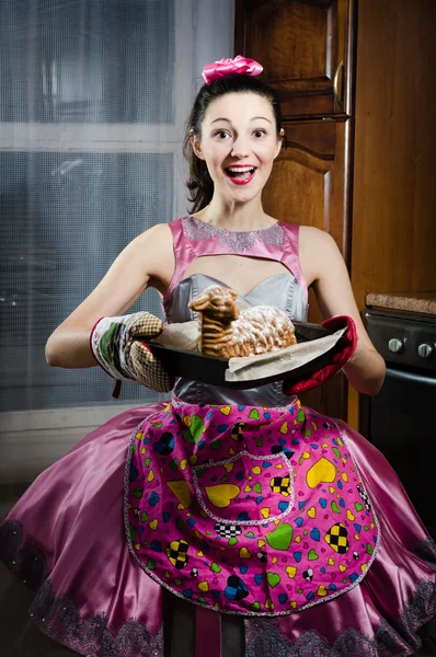 Портрет очаровательной искренней смешной пинап девушка брюнетка девушка в платье фартук весело улыбаясь выпечки вкусный торт и глядя на изображение камеры — стоковое фото