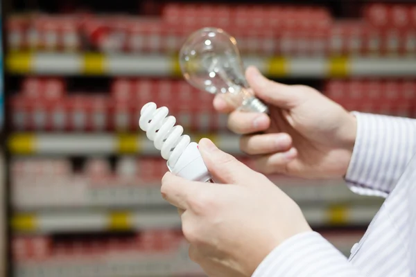 Homme choisissant la lampe dans le supermarché — Photo