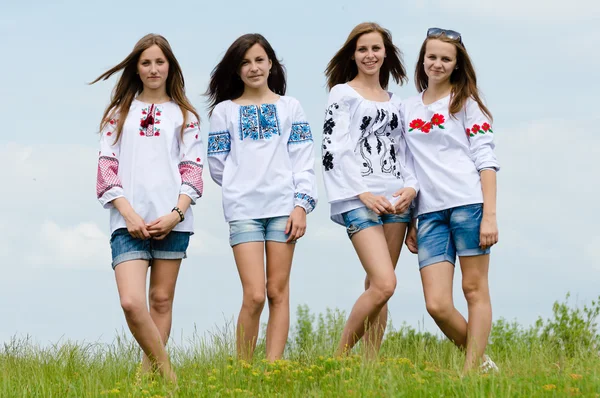 Quatro felizes amigos adolescentes posando em blusas feitas à mão contra o céu azul — Fotografia de Stock