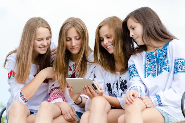 Dört mutlu teen kız arkadaş ve tablet bilgisayar — Stok fotoğraf