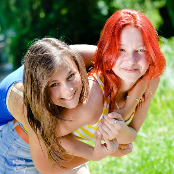 2 chicas amigas jóvenes mujeres bonitas felices sonriendo divirtiéndose abrazándose juntas y mirando a la cámara en el parque verde de verano al aire libre copiar espacio fondo primer plano retrato —  Fotos de Stock