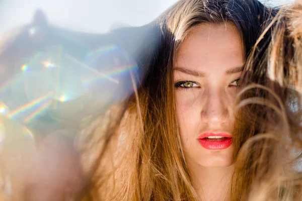 Como uma fada: close-up em adorável jovem menina bonita morena com lábios vermelhos se divertindo sensualmente olhando para a câmera em chamas de luz solar de raios ao ar livre imagem retrato — Fotografia de Stock