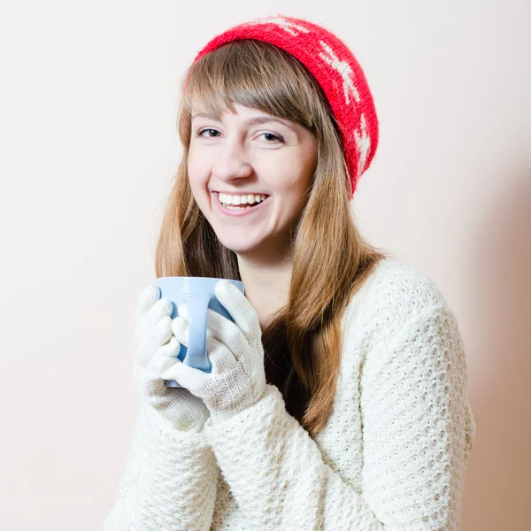 Chapéu vermelho & copo: retrato de menina bonita em luvas de malha e boné com um padrão flocos de neve, camisola branca ter bebida bebida bebida divertida feliz sorrindo & olhando para a câmera no fundo espaço de cópia de luz — Fotografia de Stock