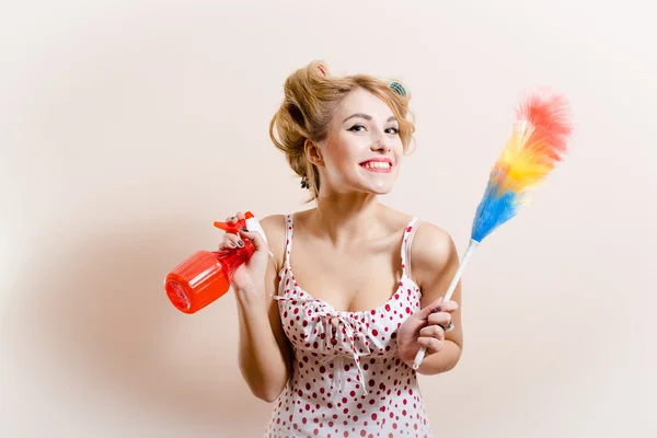 Gorgeous sexy funny blond pinup girl having fun holding dust sweeping brush and sprinkler looking at camera happy smile on white or light copy space background portrait picture — Stock Photo, Image