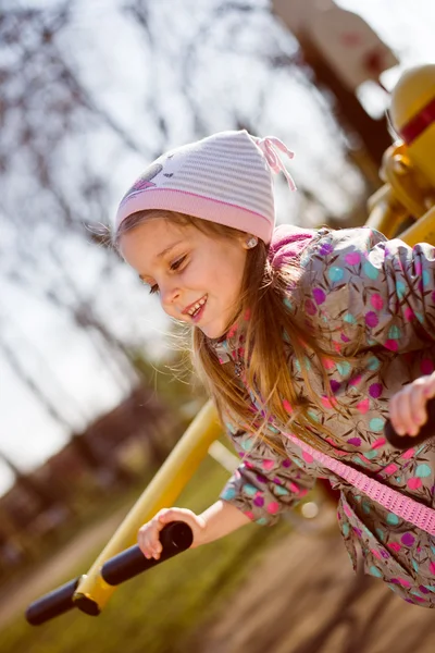 Niña montando un columpio en el parque — Foto de Stock