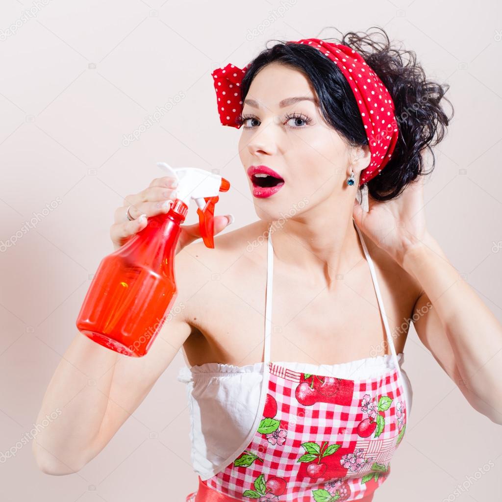 closeup on glamor dehydration: gorgeous funny young brunette pinup lady having fun holding sprinkler and spraying in mouth looking at camera over white or light copy space background portrait picture