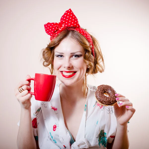 Пинап девушка с красной чашкой и пончиком — стоковое фото