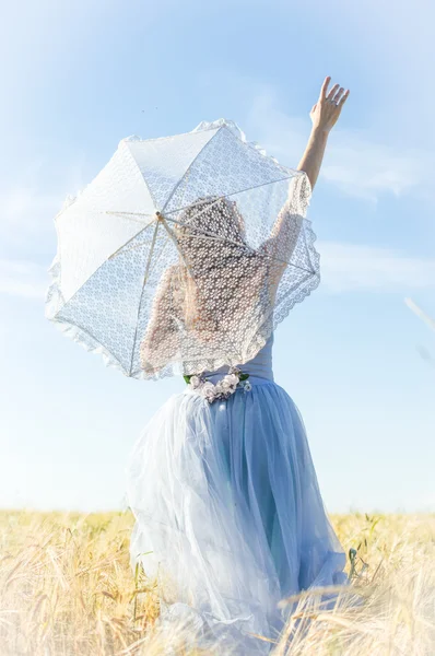 Женщина в бальном платье с белым зонтом — стоковое фото