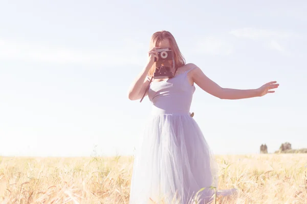 Mulher vestindo vestido de bola tirar foto na câmera retro — Fotografia de Stock