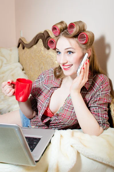 Woman talking on mobile phone and working on laptop — Stock Photo, Image