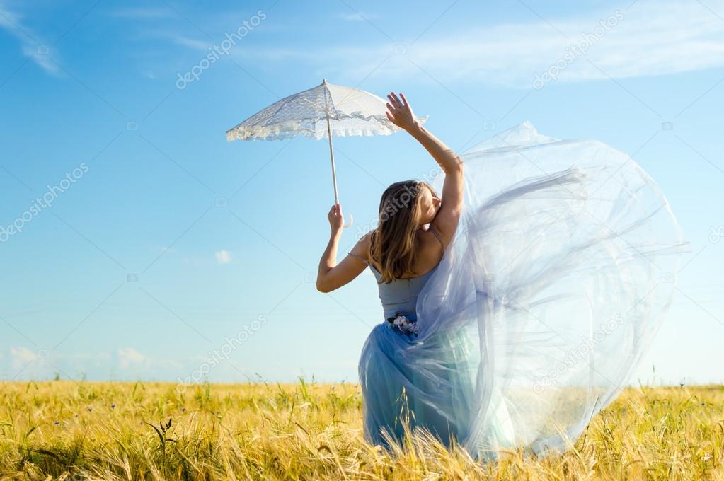 Woman in ball dress holding white umbrella