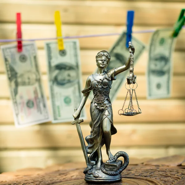 Geldwäsche-Konzept: Bild der Göttin Themis oder Justizdame mit verbundenen Augen und USD-Scheinen, die auf dem Hintergrund des Kopierraums hängen — Stockfoto