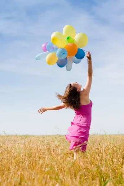 Afbeelding van plezier romantische blond jonge dame houden lucht ballonnen hardlopen of walken in het veld op zomer blauwe hemel buitenshuis kopie ruimte achtergrond — Stockfoto