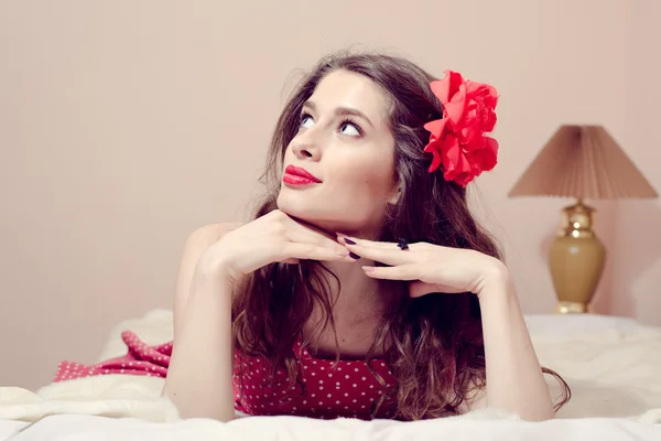 Chica con lápiz labial rojo relajarse en la cama mirando hacia arriba —  Fotos de Stock
