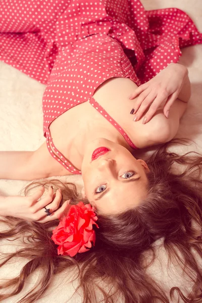 Pinup girl in polka dot dress relaxing in bed — Stock Photo, Image