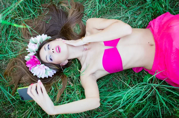 Mujer acostada graciosamente sobre hierba verde — Foto de Stock