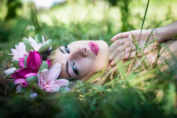 Žena na lůžku elegantně na zelené trávě — Stock fotografie