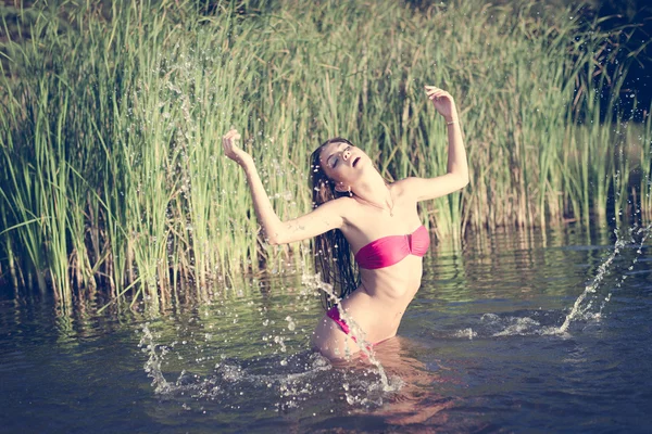 Chica en bikini rosa de pie en el agua —  Fotos de Stock