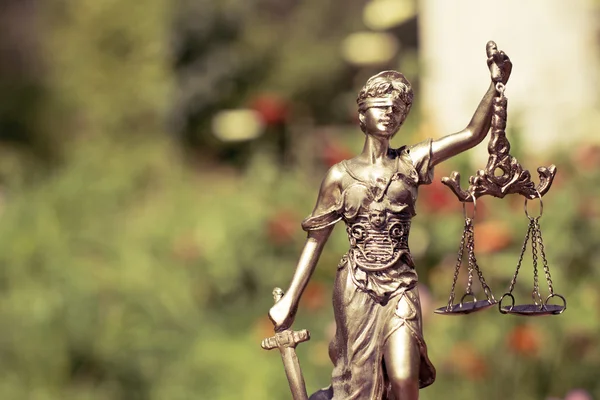 Sculptuur van themis, femida of Justitie godin op groen laat natuurlijke bokeh achtergrond — Stockfoto