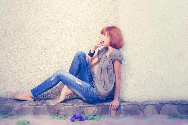 Bella ragazza romantica in jeans seduta & guardando lo spazio copia con rosa blu fiori mazzo vicino a lei su sfondo copyspace luce, ritratto — Foto Stock