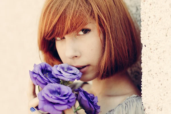 Red haired woman smelling purple flower — Stock Photo, Image