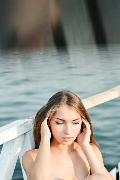 Blond flicka avkopplande på stranden — Stockfoto