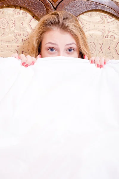 Woman hiding under white blanket — Stock Photo, Image