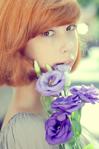 Νέα γυναίκα που κρατά μπλε ροδαλά λουλούδια — Φωτογραφία Αρχείου