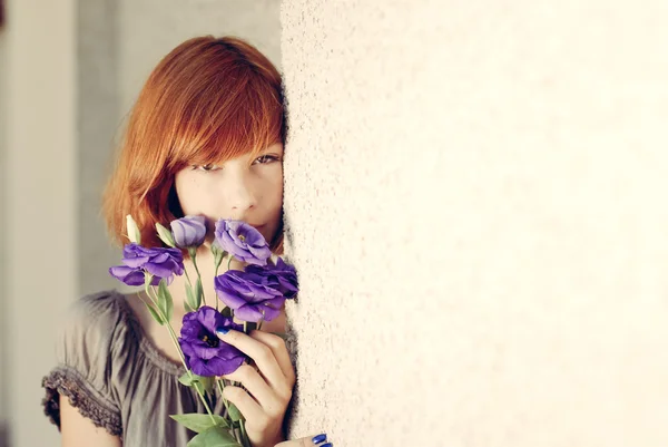 紫の花の臭いがする赤髪の女性 — ストック写真