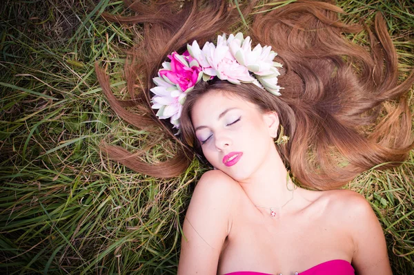 Mulher deitada graciosamente na grama verde — Fotografia de Stock