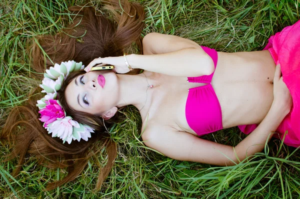Vrouw liggend sierlijk op groen gras — Stockfoto