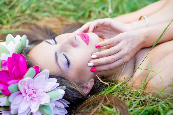 Vrouw liggend sierlijk op groen gras — Stockfoto