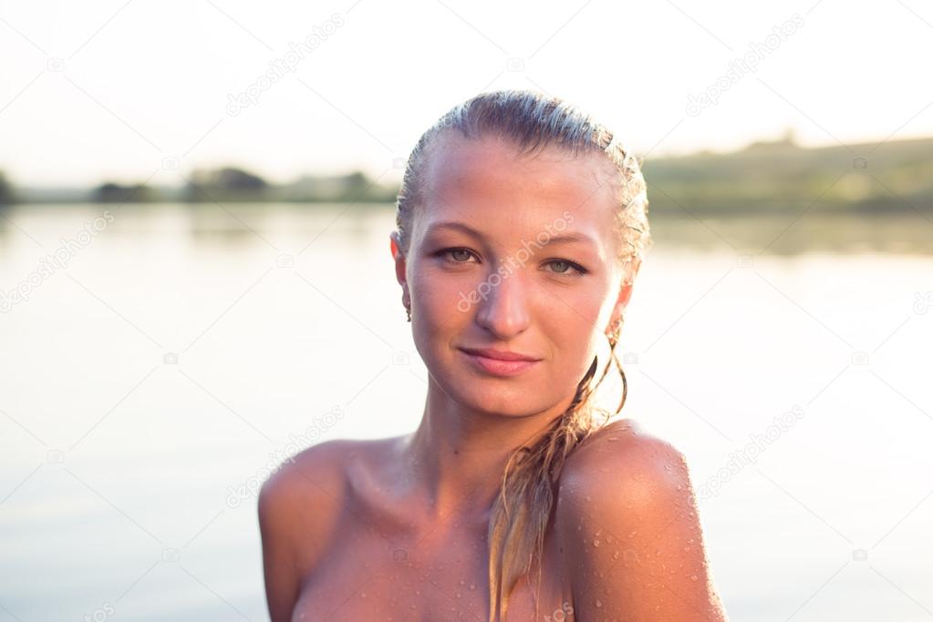 Girl with naked shoulders in open water