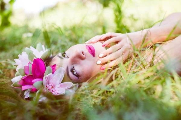 Vrouw liggend sierlijk op groen gras — Stockfoto