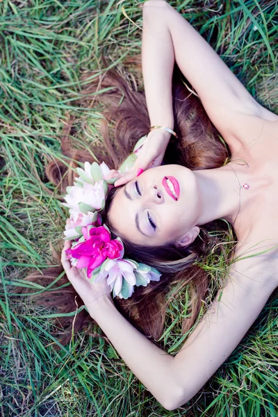 Mujer acostada graciosamente sobre hierba verde — Foto de Stock