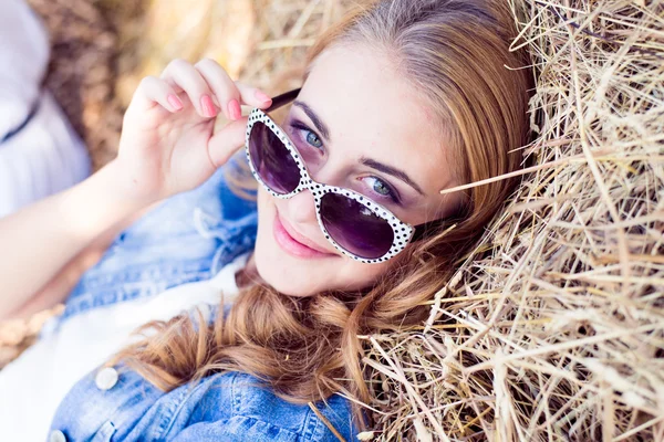 Blond girl relaxing on hay — Stock Photo, Image
