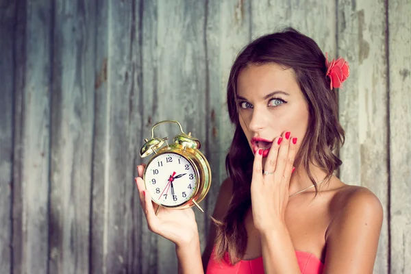 Girl holding alarm clock in hand — Stock Photo, Image