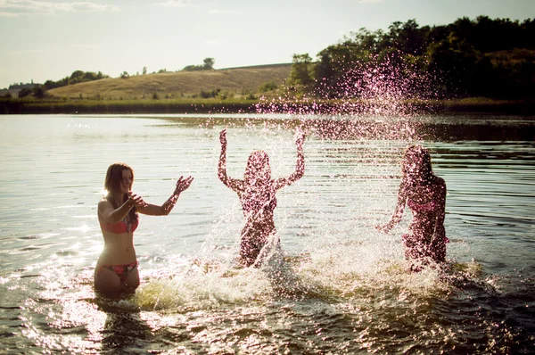 Three women splashing water in river — Stock Photo, Image