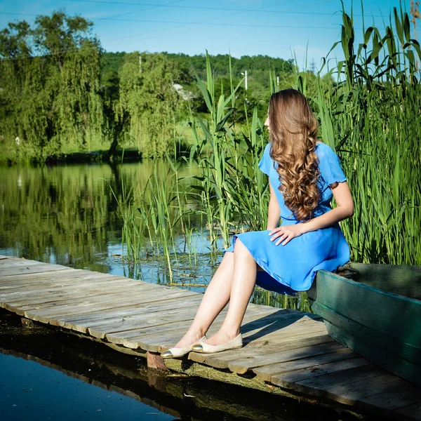 Bella signora rilassante sul molo del fiume — Foto Stock