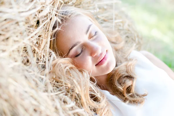 Mujer joven rubia durmiendo en el heno —  Fotos de Stock