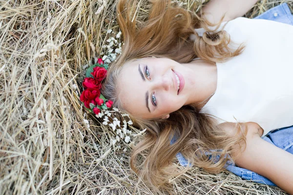 Pretty girl with blue eyes laying on hay — Stock Photo, Image