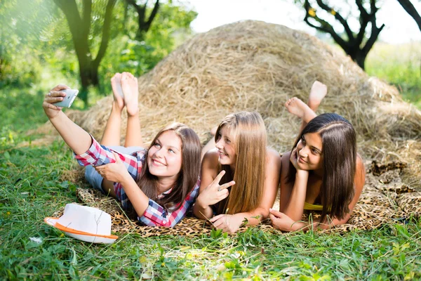 Girls lying on hay and making selfish — Stock Photo, Image