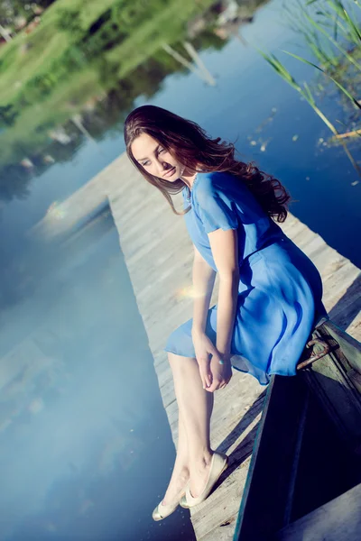 Леди расслабляется сидя в повседневном синем платье — стоковое фото