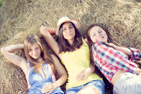 干し草の上に横たわる 3 つの可愛い女の子 — ストック写真
