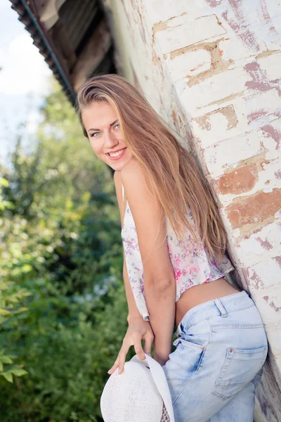 Блондинка позирует на стене загородного сарая — стоковое фото