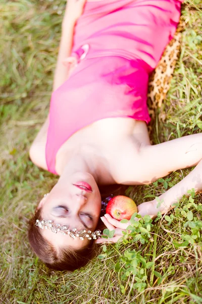 Jonge vrouw liggend op groen gras — Stockfoto