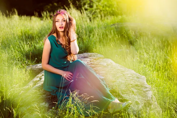 Brunette girl sitting on stone — Stock Photo, Image